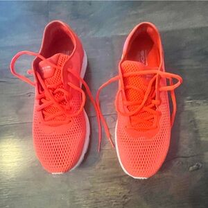 Bright Orange UA tennis shoes.